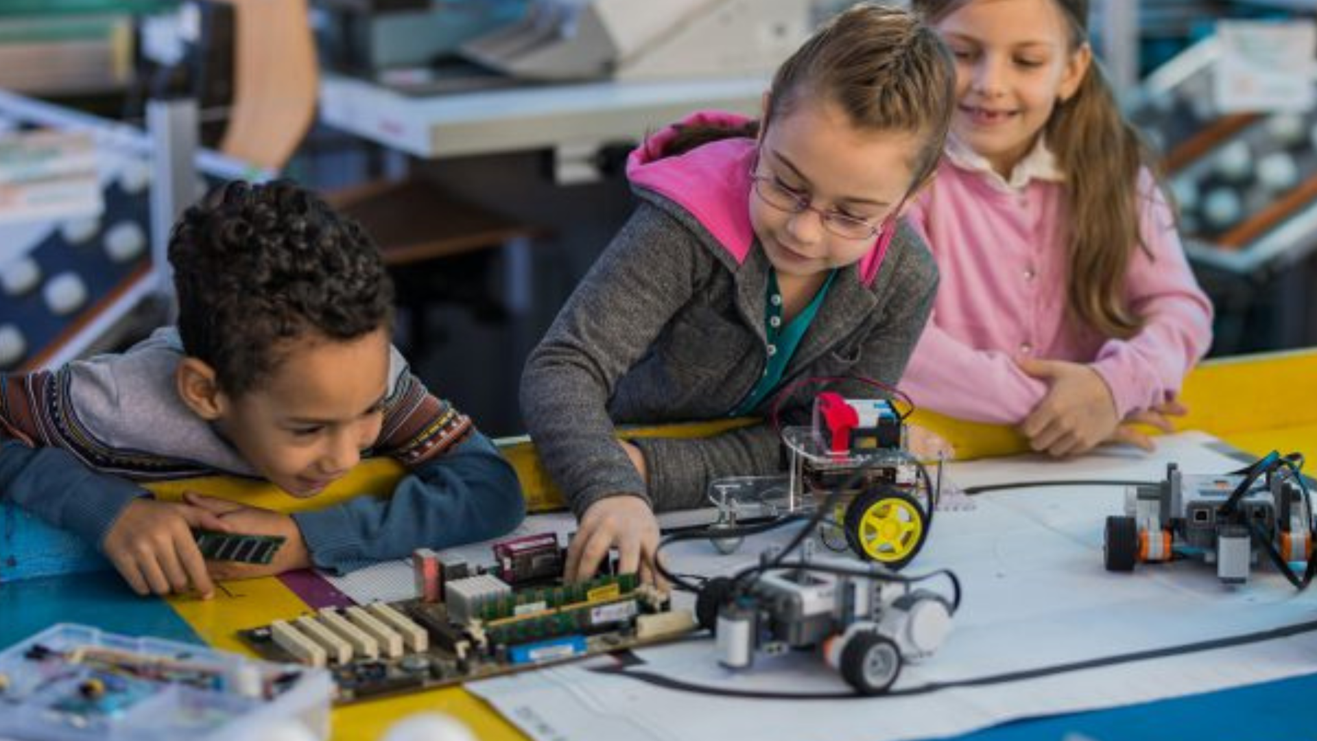 Three kids working on a robotics project